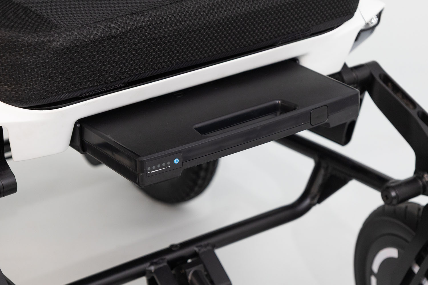 Batería extraíble bajo el asiento de una silla de ruedas eléctrica ergoflix.